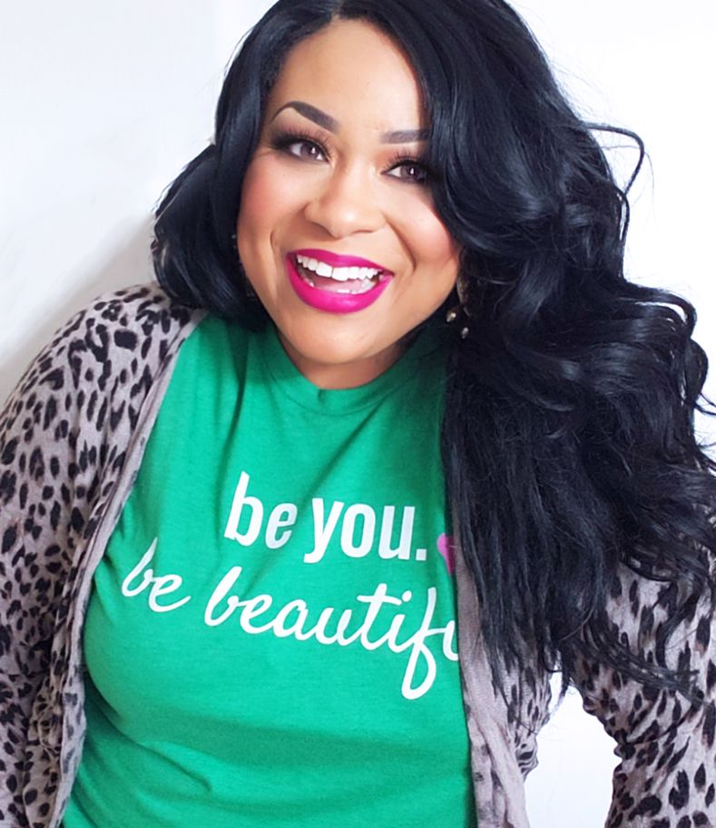 La dietista registrada Andrea Mathis sonríe mientras lleva una blusa color verde y un cárdigan con estampado de guepardo.