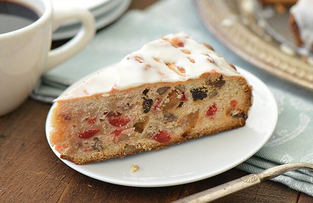 Una rodaja de panetón relleno de frutos secos y nueces en un plato con un tenedor.