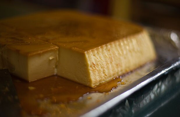 Un flan rectangular sobre una charola con caramelo por encima y por debajo.