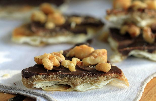 Crackers de toffee con nueces picadas por encima enfriándose sobre una servilleta de tela.