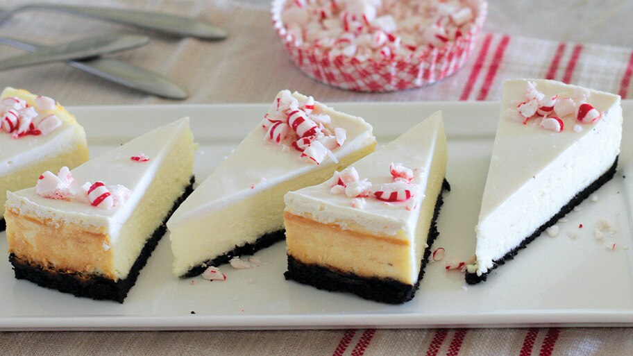 Una espátula levanta una rebanada de pay de queso con corteza de galleta de chocolate.