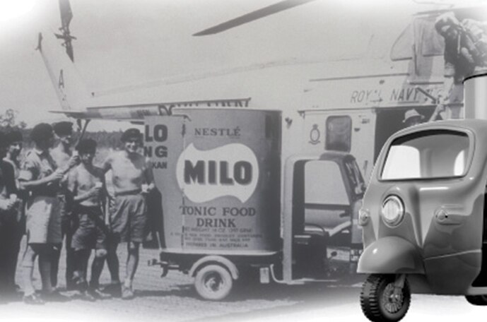 A black and white image of a vintage scooter and a group of people standing near a MILO delivery truck.