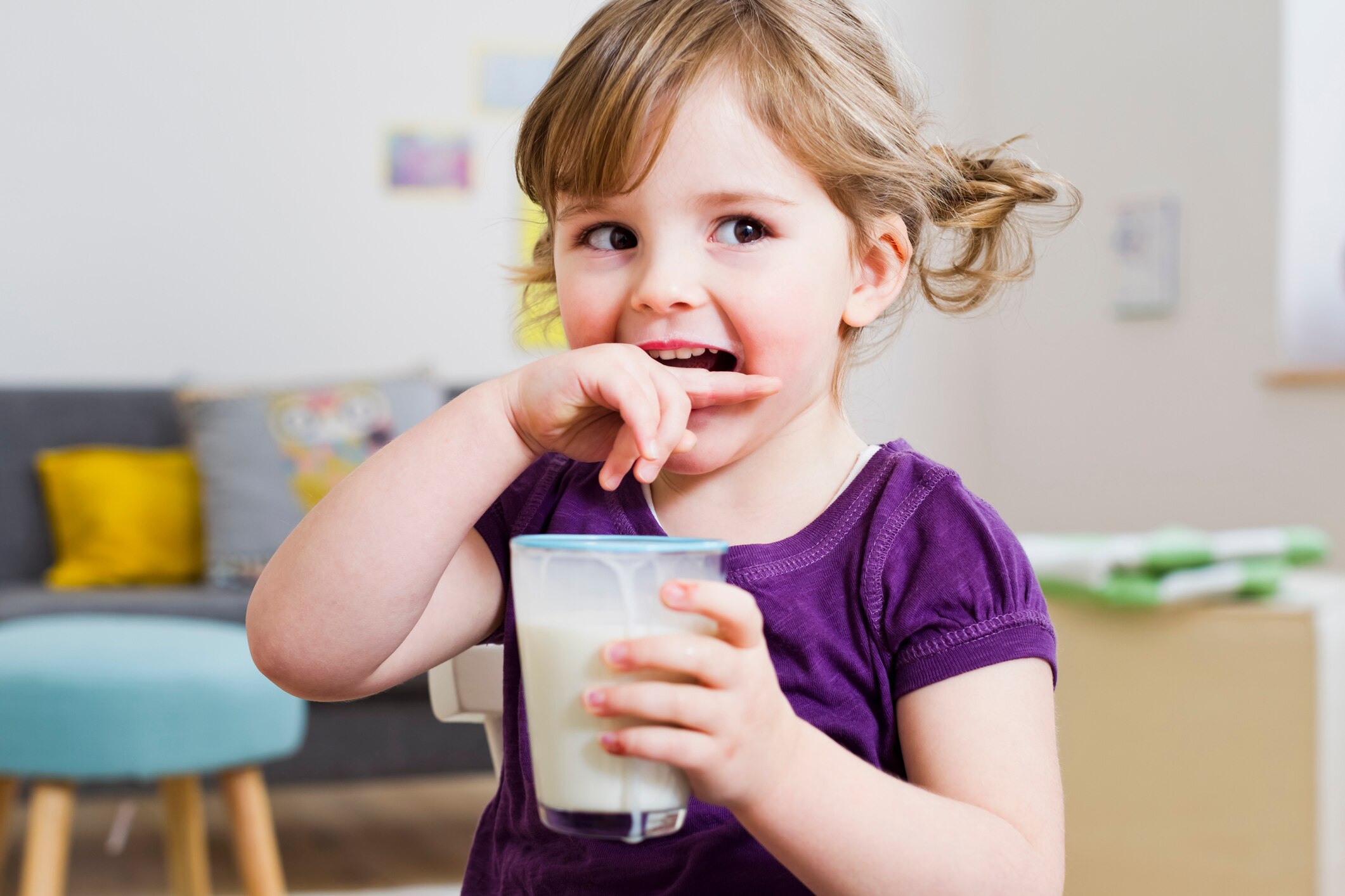 Girl drinking milk and smiling.