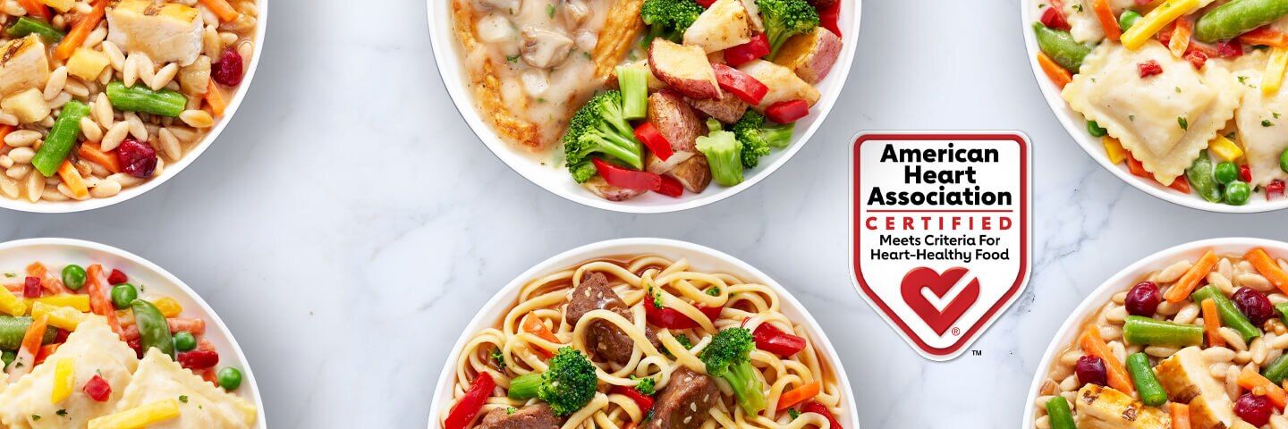 Plates of 4 American Heart Association Certified Lean Cuisine meals by the AHA Certified Heart-Check badge.