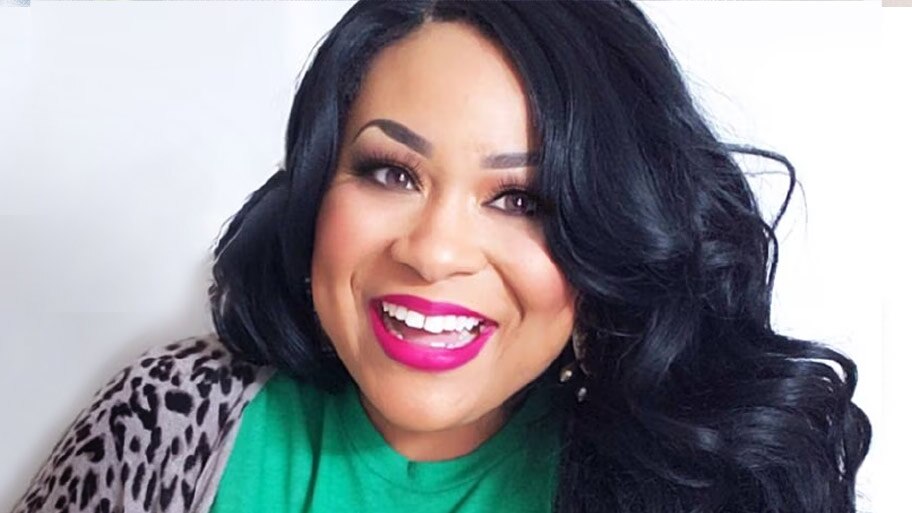 Registered Dietician Andrea Mathis smiles wearing a green shirt and cheetah print cardigan.