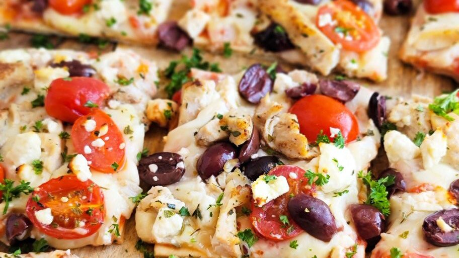 A DiGiorno Four Cheese Thin Crust pizza topped with chicken, feta cheese, kalamata olives and cherry tomatoes.