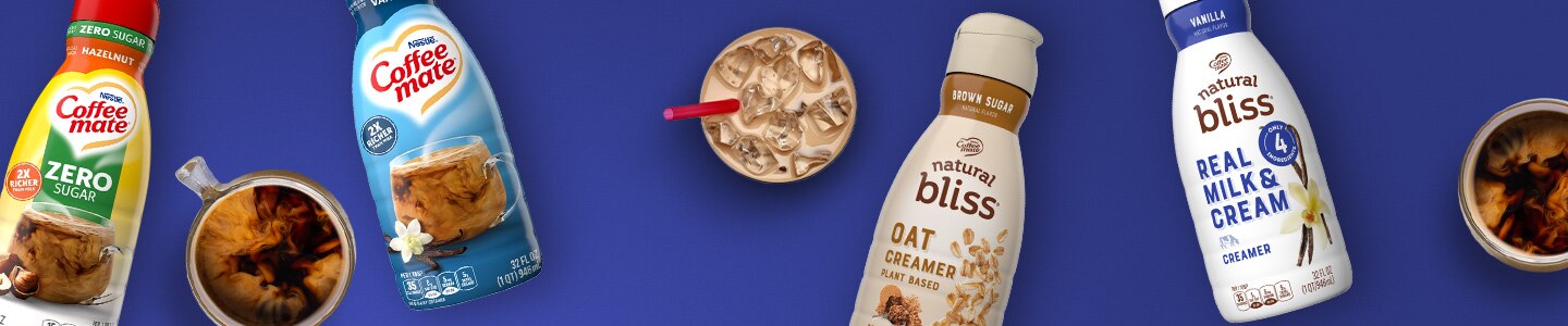 Vanilla Real Milk & Cream, Oat Creamer, Zero Sugar Hazelnut & Vanilla Creamers next to coffee drinks on a blue surface.