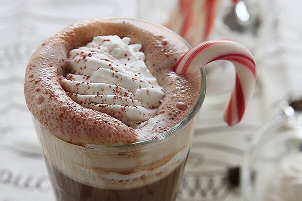 A sparkling mint mocha with whipped cream and a candy cane.