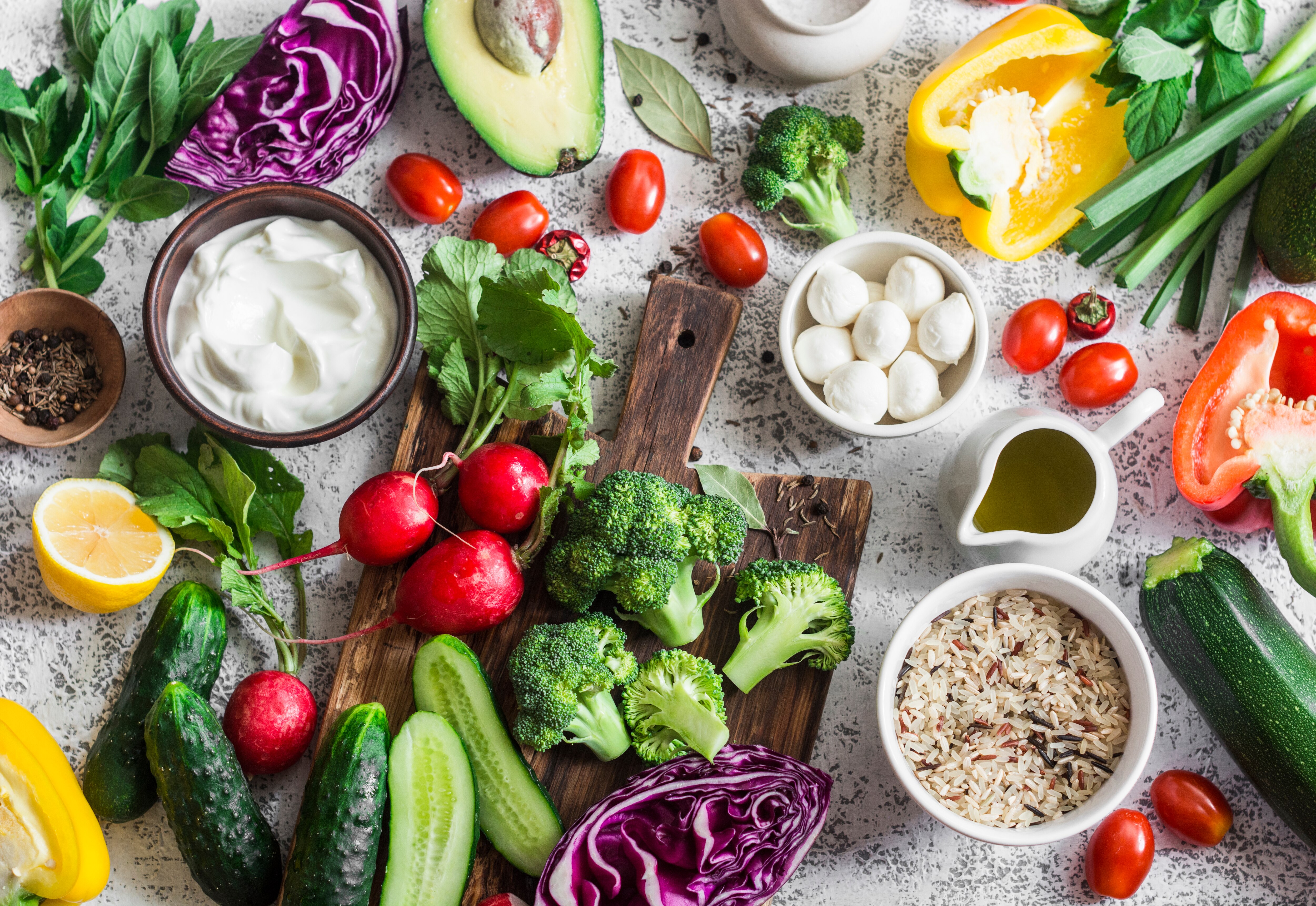 An assortment of vegetables and dips spread across a white table.
