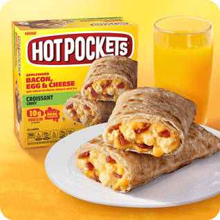 Bacon, Egg & Cheese Hot Pockets® on a plate next to orange juice and packaging.