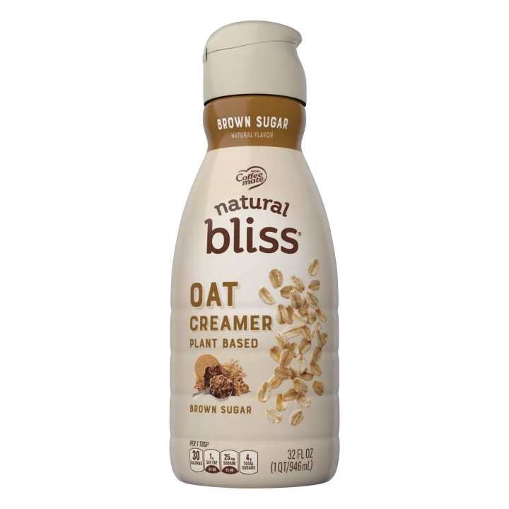 A brown bottle of natural bliss Oat Brown Sugar Creamer with a brown label above a measuring cup of brown sugar.