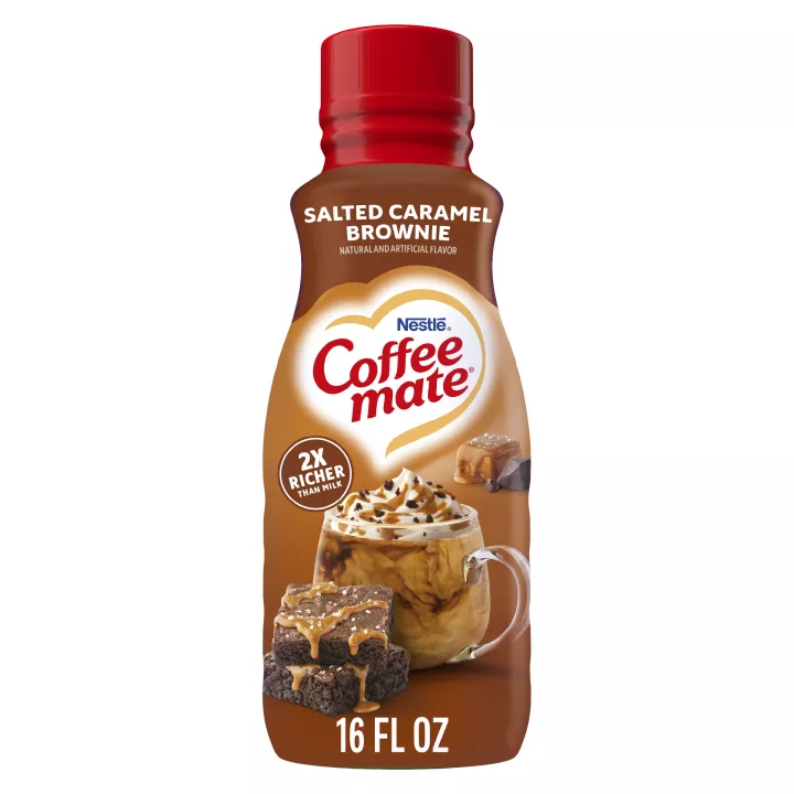 Bottle of Salted Caramel Brownie Coffee Creamer with 2x richer than milk label above a coffee mug, brownies & caramel square.