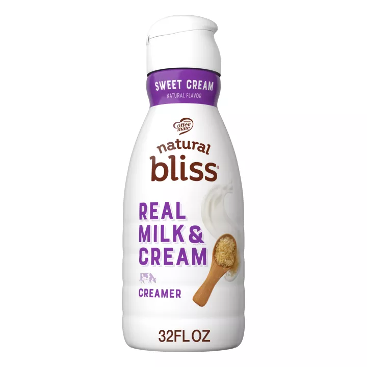White bottle of natural bliss Sweet Cream flavored Creamer with a purple label above a spoon of sugar and swirl of milk.