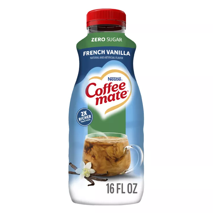 A blue bottle of Zero Sugar French Vanilla Coffee Creamer with a Zero Sugar label above a coffee mug and vanilla beans.