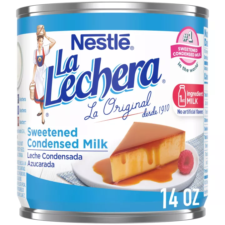 A white can of sweetened condensed milk with blue labels beside the La Lechera logo and a plate of flan.