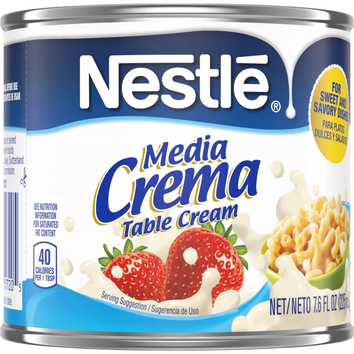 A can of Media Crema table cream with a blue label featuring strawberries, a bowl of macaroni, and cream.