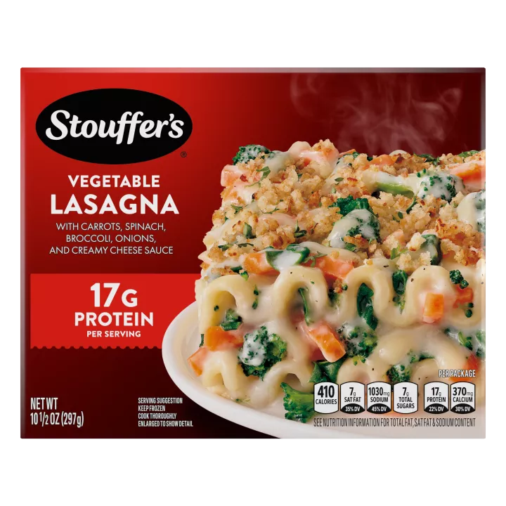 Box of Veggie Lovers Lasagna with a plate of lasagna on a table under the product name and STOUFFER'S logo.