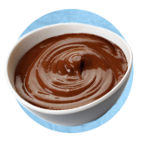 Close up of a chocolate sauce in a small white bowl, on a blue background.