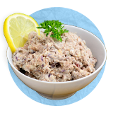 Close up of a tuna salad in a white bowl garnished with a lemon wheel, on a blue background.