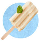 Close up of a popsicle on a stick with a mint leaf on it, on a blue background.