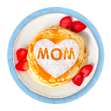 Overhead pancakes on white plate with strawberries, and mom in a heart shape made from powdered sugar, on a blue background.