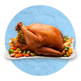 Close up of a roasted turkey on a white serving dish, on a blue background.