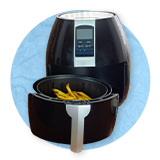 Primer plano de una freidora de aire abierta sobre un fondo azul.