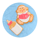 Close up of a cookie shaped and decorated like a baby and a baby bottle, on a blue background.