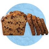 Close up of a loaf of cinnamon raisin bread with four sliced pieces leaning on it adjacently, on a blue background.
