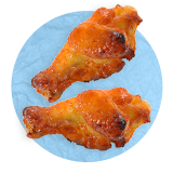 Close up of a couple of buffalo chicken wings on a blue background.