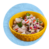 Close up of small yellow bowl filled with seafood ceviche, on a blue background.