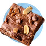 Close up of a piece of chocolate fudge with almonds on it, on a blue background.