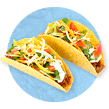 Close up of a couple of beef tacos on hard shell, on a blue background.
