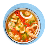 Overhead of a bowl of seafood stew, on a blue background.