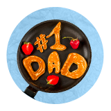 Close up of a cast iron skillet with pancakes shaped to spell out, number 1 dad, on a blue background.