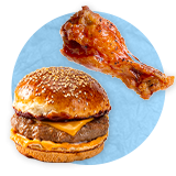 Close up of a cheeseburger on sesame bun, and a piece of bacon next to it, on a blue background.