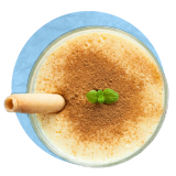 Overhead close up of a custard sprinkled with cinnamon, on a blue background.