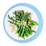 Overhead of a bunch of cooked asparagus on a white plate, on a blue background.
