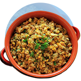 A dutch oven filled with Guatemalan stuffing on an orange circle.