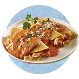 A plate of fish enchiladas al pastor with cilantro and sauce garnish on blue background