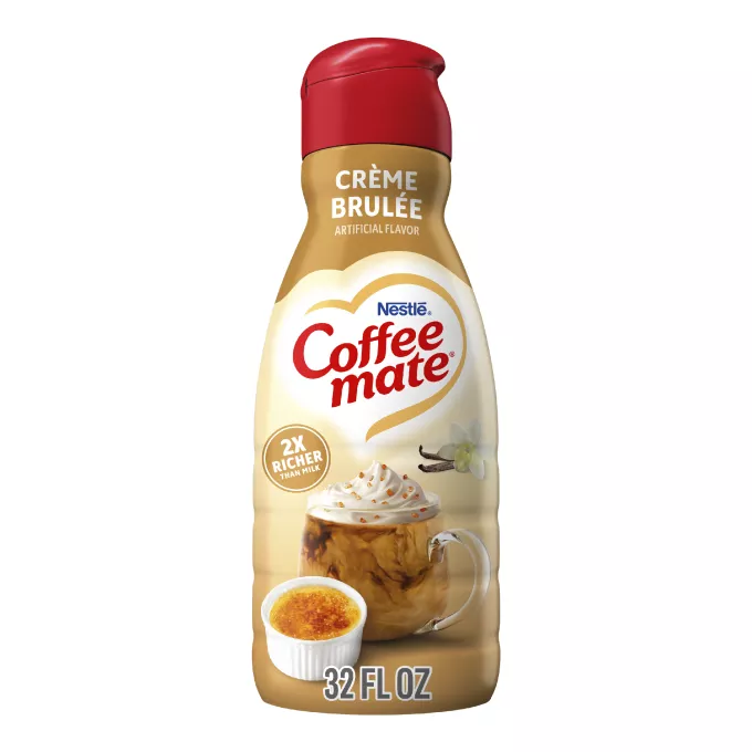 Una botella de creamer Coffee mate Crème Brulee con una etiqueta y una tapa roja encima de vainas de vainilla, Crème Brulee y el logotipo del producto.