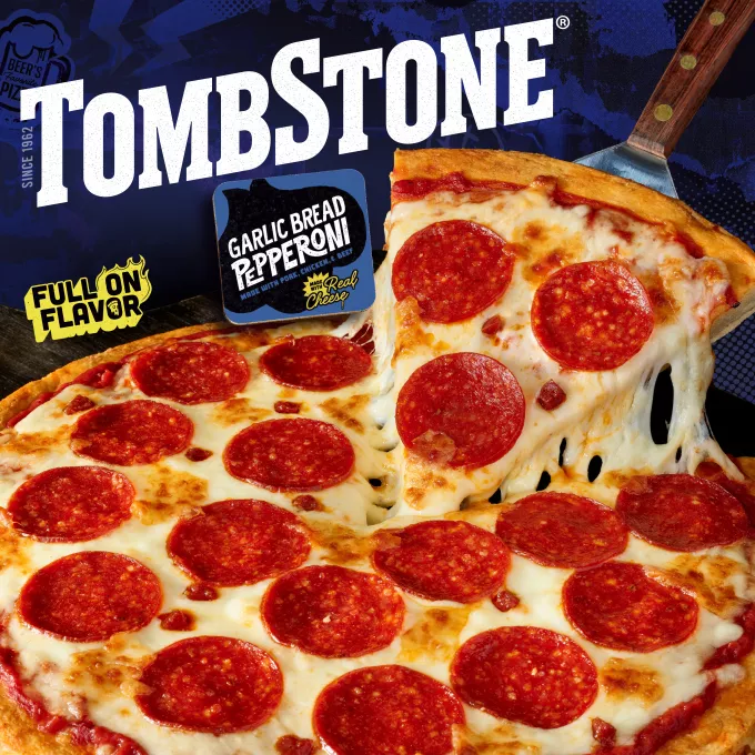 Package of garlic bread pepperoni pizza with a blue label and border, a spatula under a pizza, and the Tombstone logo with a Quarter Pound of Cheese and Bold and Zesty Sauce badge.