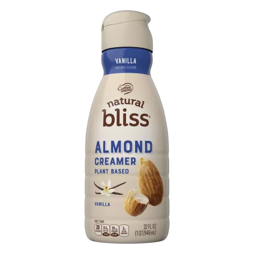 A beige bottle of natural bliss vanilla flavor almond milk creamer with a blue label above vanilla beans and almonds.