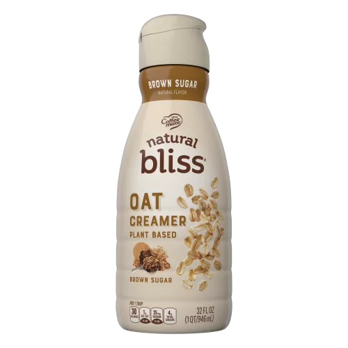 A brown bottle of natural bliss Oat Brown Sugar Creamer with a brown label above a measuring cup of brown sugar.
