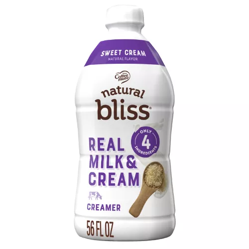 Large white bottle of natural bliss Sweet Cream flavored Creamer with a purple label above a spoon of sugar and swirl of milk