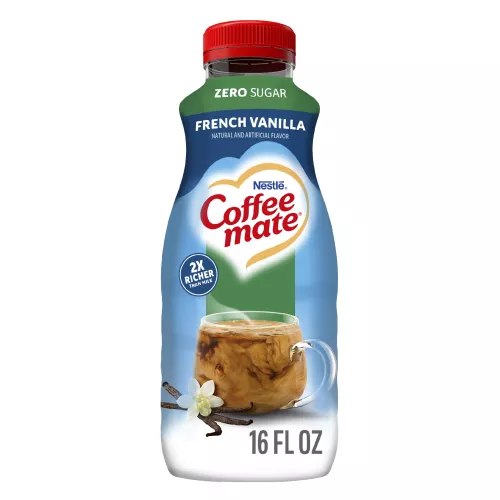 A blue bottle of Zero Sugar French Vanilla Coffee Creamer with a Zero Sugar label above a coffee mug and vanilla beans.