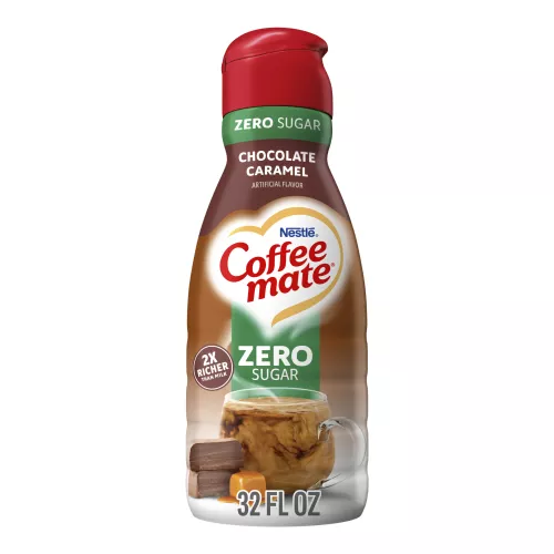 A brown bottle of Zero Sugar Chocolate Caramel Creamer with a green label, a coffee mug, and caramel chocolates.