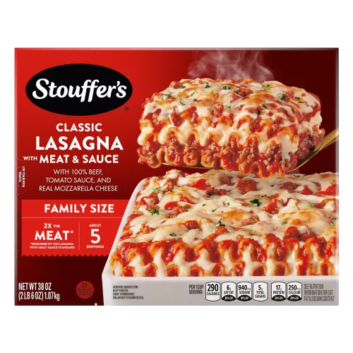 A plate of Lasagna with Meat & Sauce beside a red dish of lasagna on a table below the product name and "2x the Meat" label.