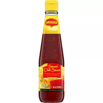 A bottle of Sweet Chili Sauce with a bright red and yellow label and egg rolls beside a cup of sauce.