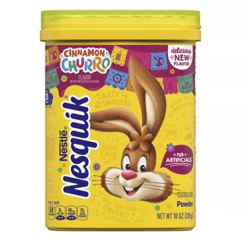 Envase de polvo NESQUIK Cinnamon Churro con el conejo de Nesquik, adornos festivos mexicanos y cartel de "Sin artificiales".